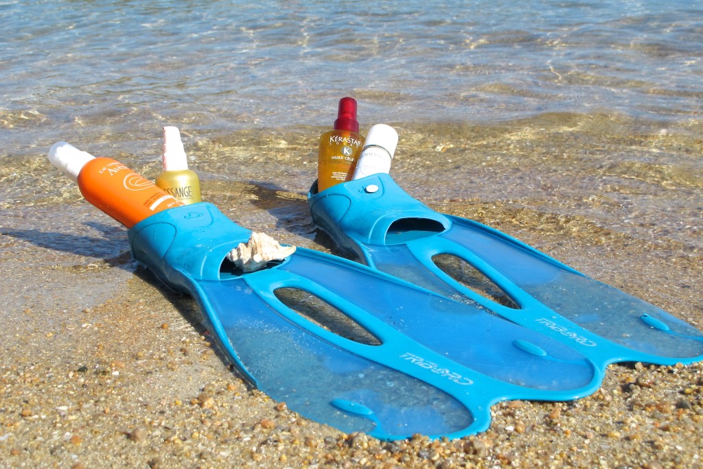 blue swim flippers filled with beauty products at the beach