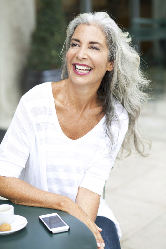 beautiful silver haired woman in a cafe laughing